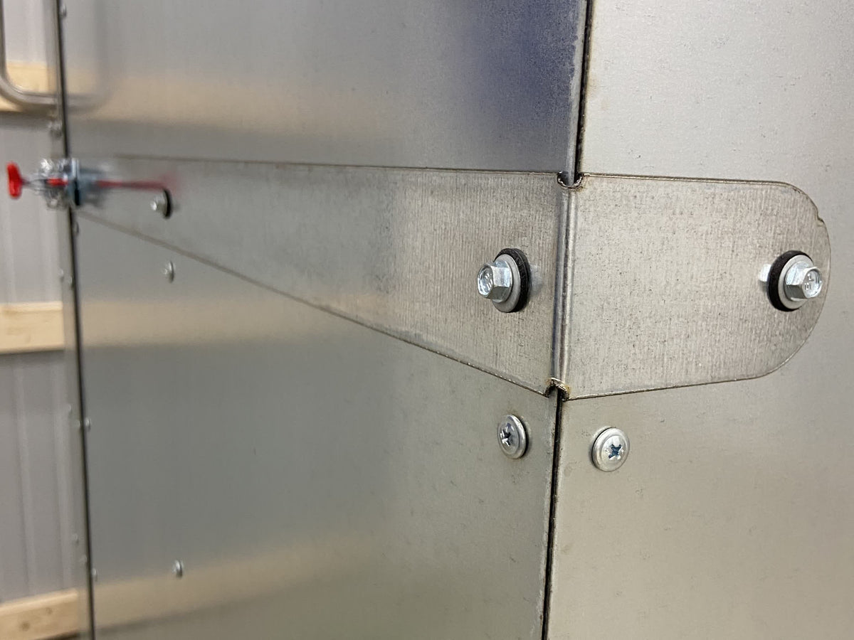 Wraparound door strap bolted through both faces of the oven corner