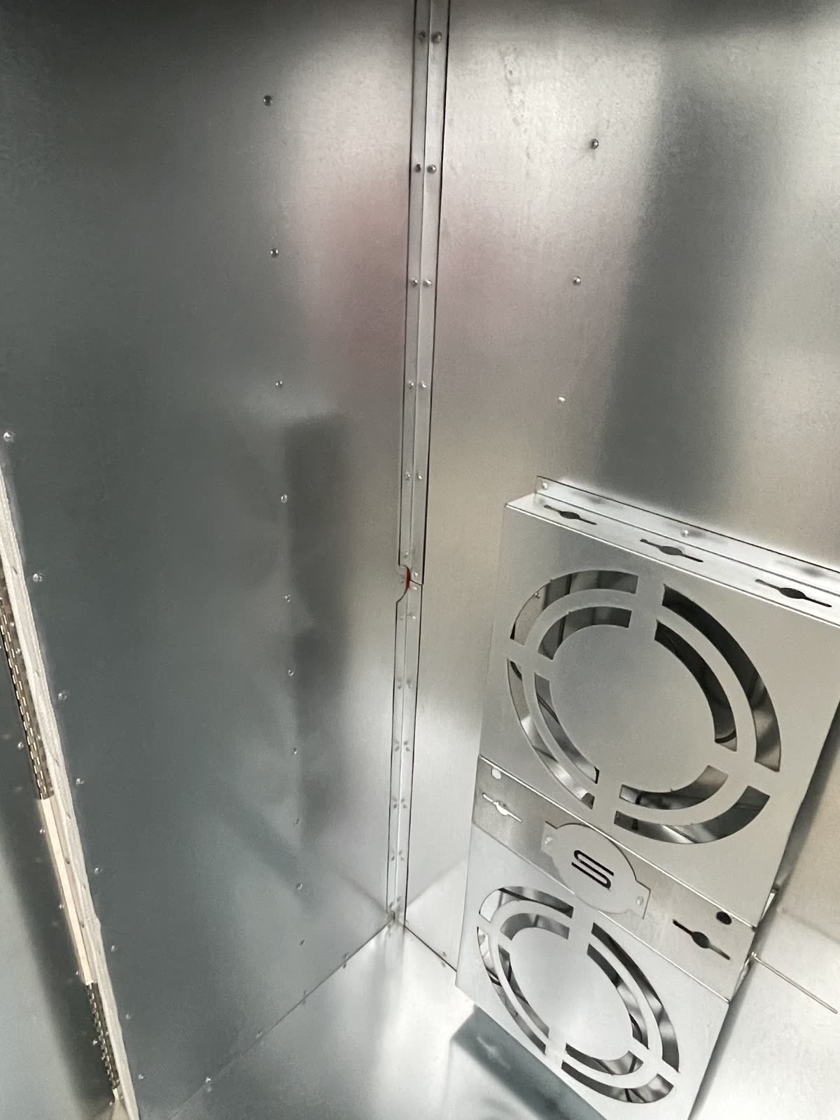 Inside corner bracket running the height of the oven wall seam with the high temp RTV seal line visible