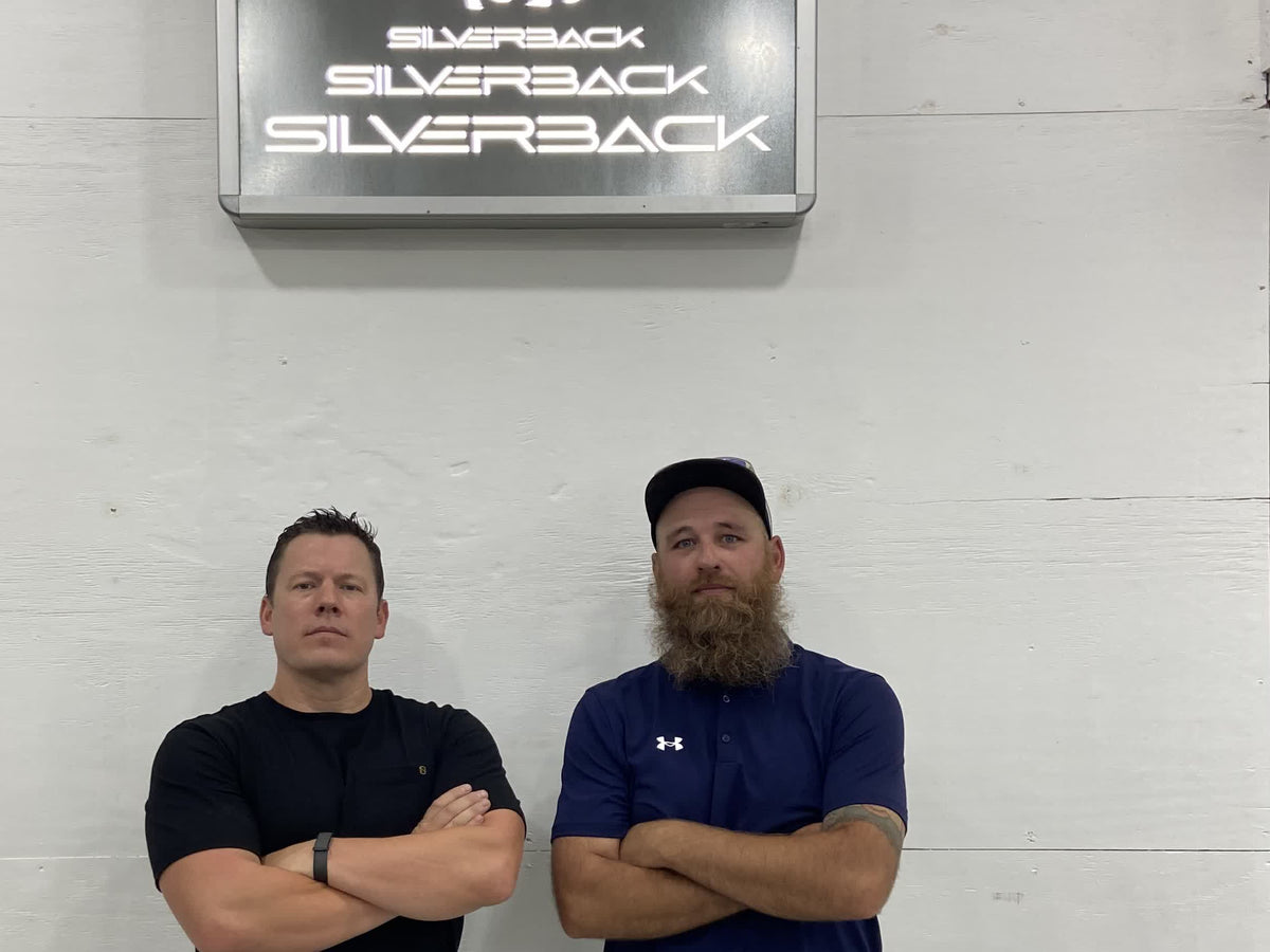 Mack and Andrew, the owners, under the Silverback sign in the shop